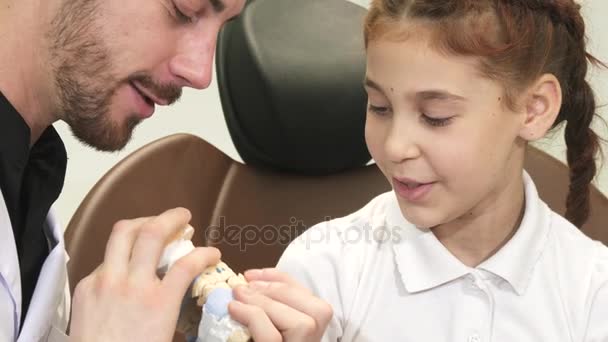 面白い医者顎の構造についての好奇心旺盛な少女を指示します。 — ストック動画