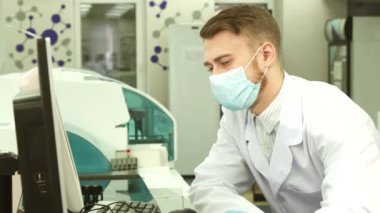 Bir hevesli Laboratuvar Görevlisi bilgisayardaki testlerin sonuçlarını inceler