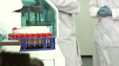 İki teknisyen test tüpleri ayaklıklı arkasındayız çekim bulanık