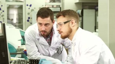 Özenli laboratuvar görevlileri bilgisayarda gördükleri test sonuçları tartışmak