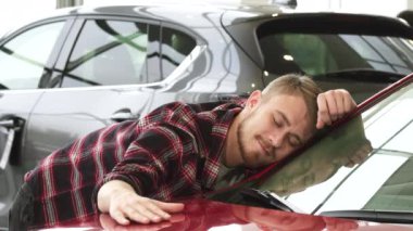 Mutlu adam yavaşça gösteren başparmak kadar galeride gülümseyen yeni arabasını okşayarak