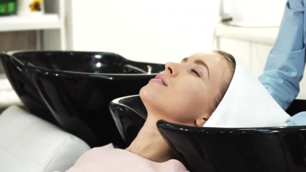 Beautiful woman smiling getting her hair dried by a professional hairdresser — Stock Video
