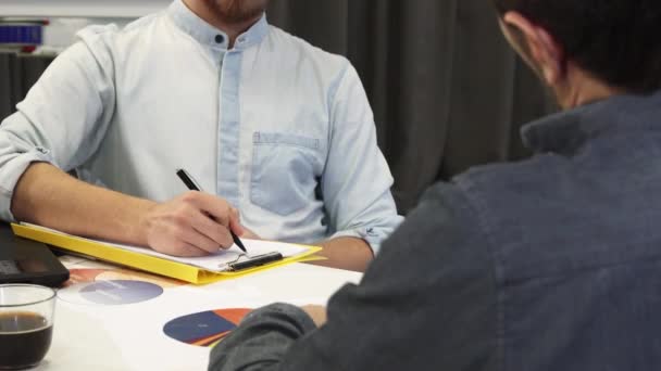 Hombre de negocios guapo tomando notas durante la reunión de negocios — Vídeo de stock