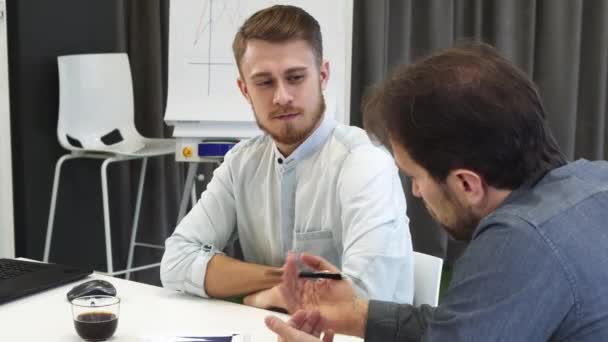 Jungunternehmer hört seinem reifen Kollegen während des Treffens zu — Stockvideo