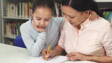 Mutlu olgun Asyalı kadın küçük kızı ile ders yardım