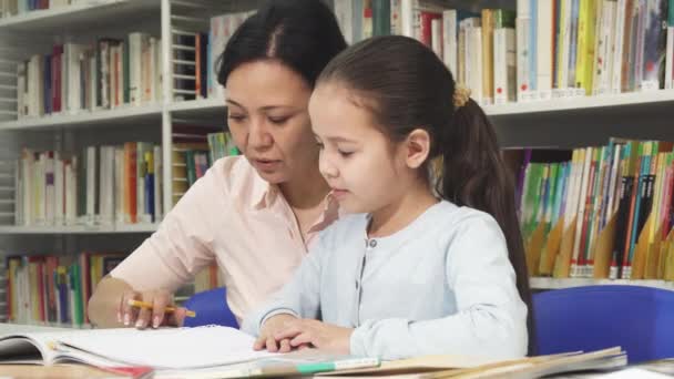可爱的小女孩做家庭作业与她的母亲 — 图库视频影像