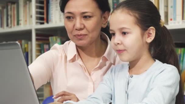 Felice madre e figlia utilizzando il computer portatile durante lo studio — Video Stock