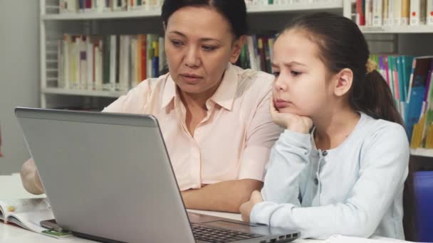 Mogna asiatisk kvinna att hjälpa hennes trött dotter med läxor — Stockvideo