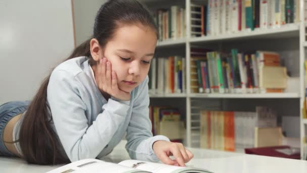Hezká malá radost Asijská dívka s úsměvem enjoyign čtení knihy — Stock video