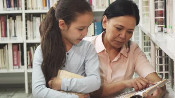 Splendida donna matura felice leggendo un libro alla sua piccola figlia — Video Stock