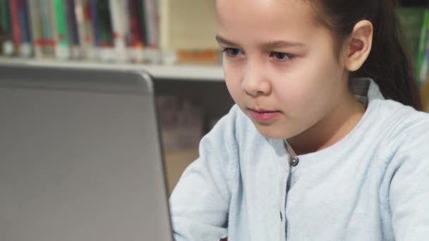 Carino bambina concentrandosi utilizzando il suo computer portatile — Video Stock