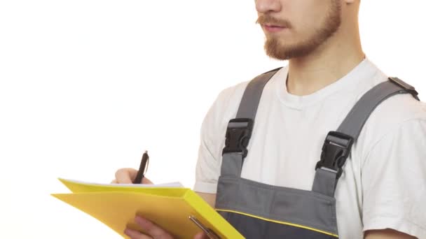 Обрізаний знімок промислового працівника, який посміхається робити нотатки на кишені — стокове відео