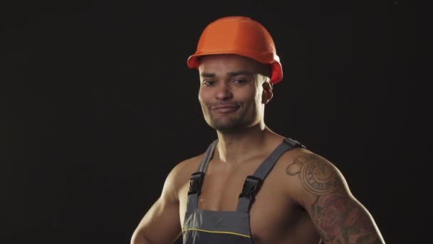 Izmos hasogatott szexi afrikai férfi builder, munkaruha és a hardhat, legördülő izmok — Stock videók