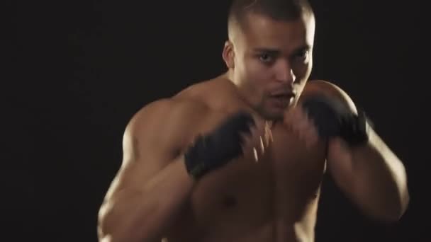 Jovem bonito lutador africano sombra boxe no fundo preto — Vídeo de Stock