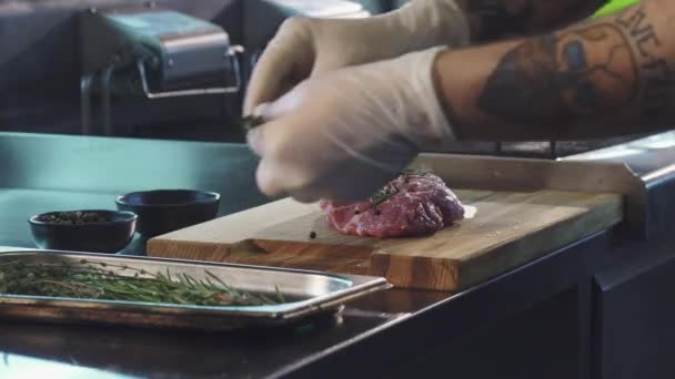 Chef professionista che aggiunge spezie sulla carne di maiale prima della cottura — Video Stock