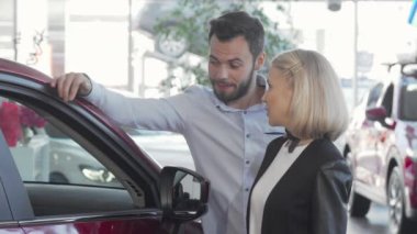 Mutlu çift galeride yeni otomobil seçiyor.