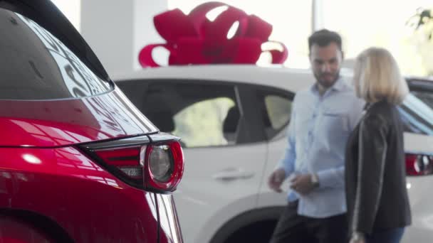 Casal amoroso escolhendo automóvel para comprar na concessionária de carros — Vídeo de Stock