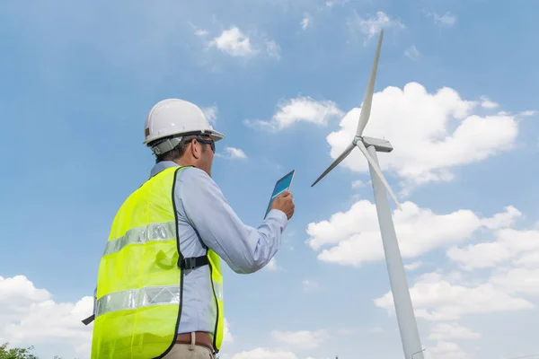 Electric Engineer writing report on Clipboard with Wind turbine — Stock Photo, Image
