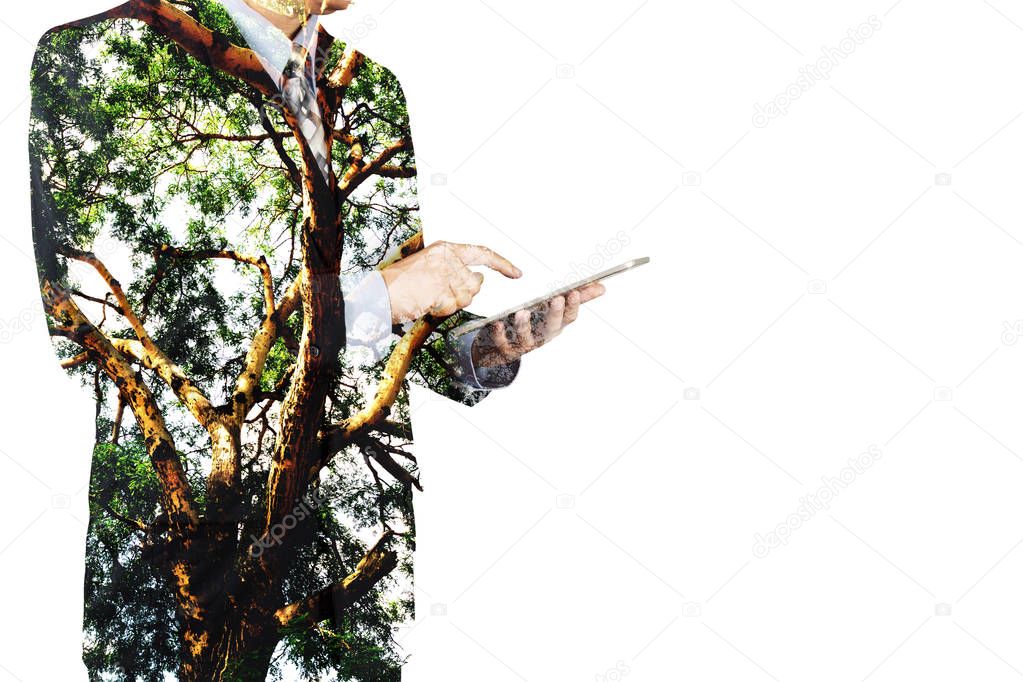 Double Exposure of Businessman use Digital Wireless Tablet with Tree and Branch as Business CSR or Technology with Nature Conservation and Freedom Think Concept. 
