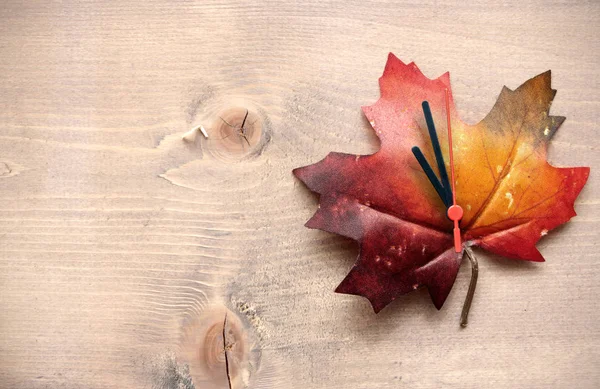 Autumn leaf with clock hands — Stock Photo, Image