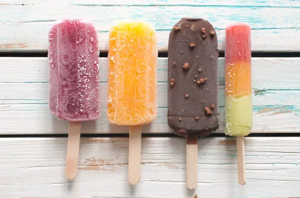Ice popsicles over wooden background — Stock Photo, Image