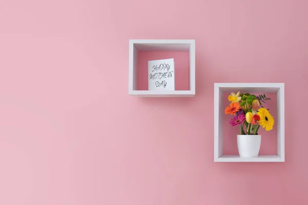 キューブ棚ディスプレイユニット内の母の日の花とグリーティングカード — ストック写真