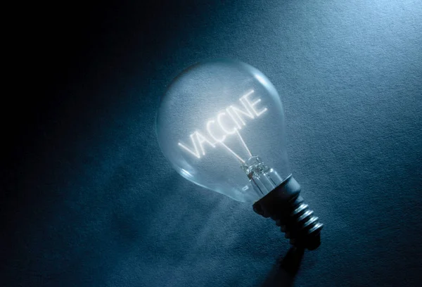 Light Bulb Illuminating Word Vaccine — Stock Photo, Image