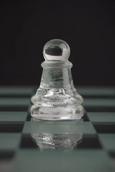Peão de xadrez de vidro no tabuleiro de queijo — Fotografia de Stock
