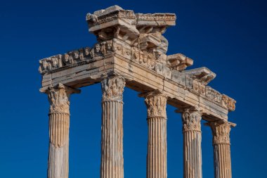 Yan taraftaki antik Apollo tapınağının kalıntıları.