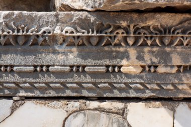 Kenarlarında antik kalıntılar, oyulmuş mermer parçaları.