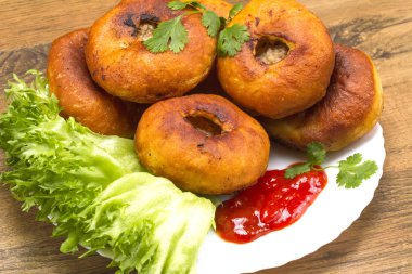 Yeşiller ve ketçap ile bir tabak kızarmış patty