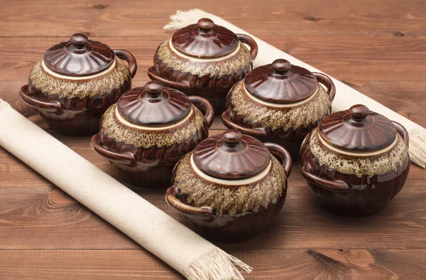 Clay potten op een houten tafel en servetten — Stockfoto