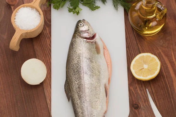 Färsk öring fisk på bordet och kryddor — Stockfoto