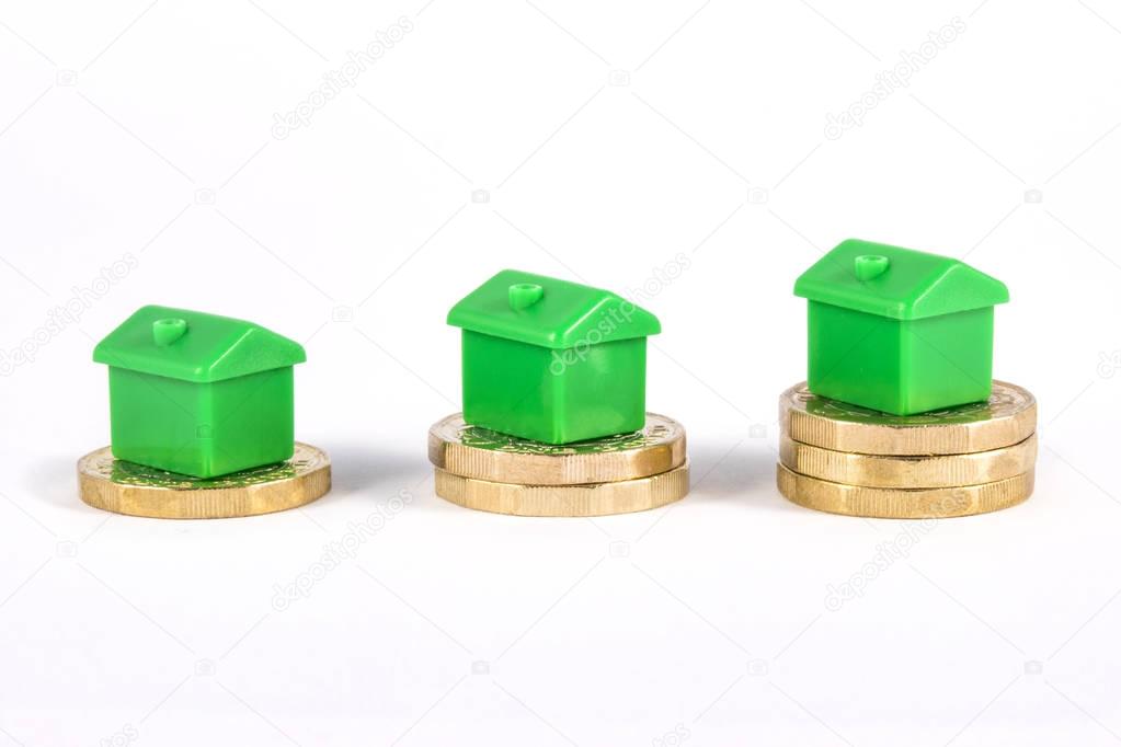 Green Houses Sitting on Top of Coins