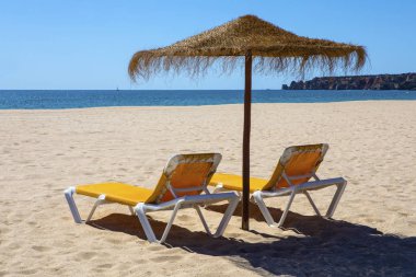 Şezlong ve şemsiye plajda