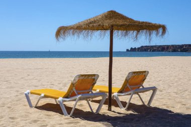 Şezlong ve şemsiye plajda