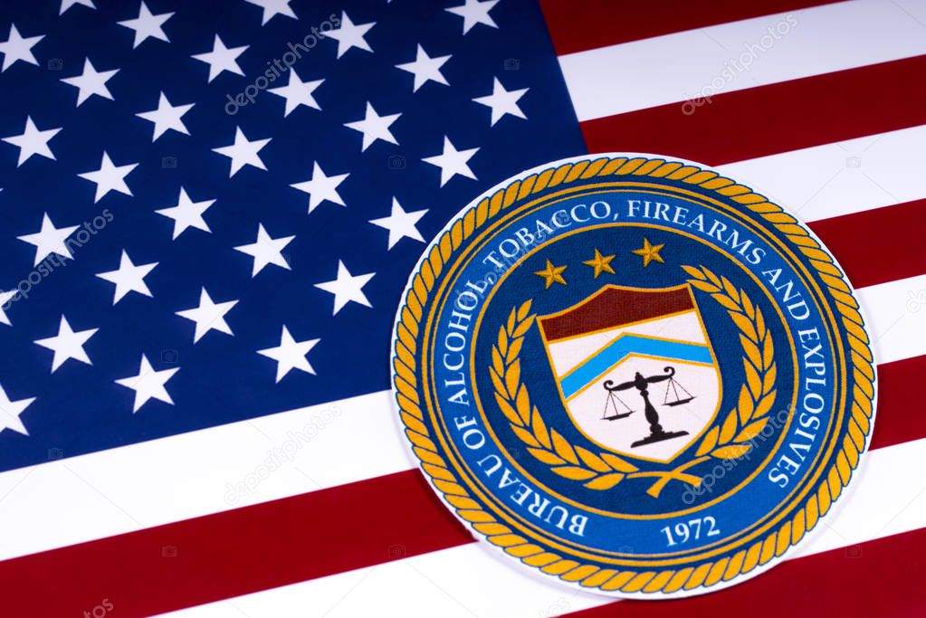 LONDON, UK - MARCH 26TH 2018: The seal or symbol of the Bureau of Alcohol, Tobacco, Firearms and Explosives, portrayed with the US flag, on 26th March 2018.
