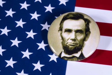 LONDON, UK - APRIL 27TH 2018: An Abraham Lincoln badge pictured over the USA Flag, on 27th April 2018.  Abraham Lincoln was the 16th President of the United States of America.  clipart
