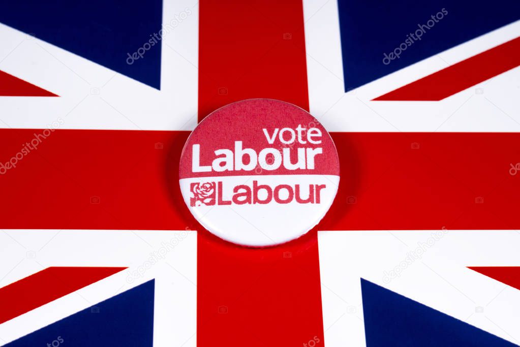 London, UK - November 21st 2019: Vote Labour pin badge, pictured over the United Kingdom flag. The UK General Election is taking place on 12th December 2019.