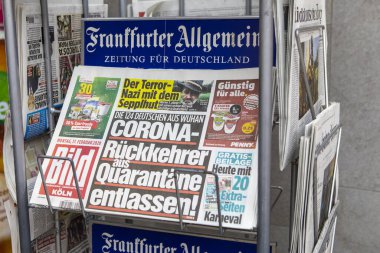 Cologne, Germany - February 17th 2020: Copies of the Bild Koln newspaper in Germany - with the the headline - Coronavirus Returnees Released from Quarantine, pictured in the city of Cologne, Germany. clipart