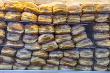 Cologne, Germany - February 19th 2020: Delicious-looking doughnuts in a bakery shop window in the historic city of Cologne in Germany.