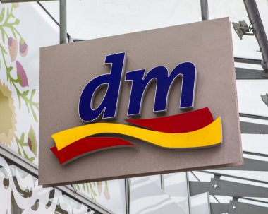 Cologne, Germany - February 20th 2020: The logo of DM-drogerie markt, above the entrance to one of their stores in Cologne, Germany.  DM is a chain of retail stores selling cosmetics, healthcare items, household products etc.