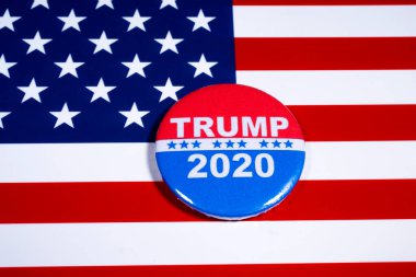 Londra, İngiltere - 5 Mayıs 2020: Donald Trump 2020 rozeti 2020 yılında Amerika Birleşik Devletleri Başkanı olarak ikinci dönem için yürüttüğü kampanyayı resmediyor. Rozet, ABD Bayrağı 'nda asılı..