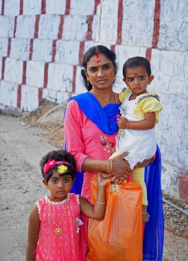 Woman on the street with two young children