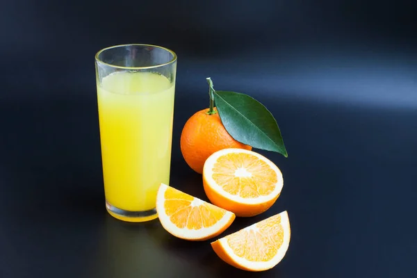Suco de laranja em um fundo preto — Fotografia de Stock