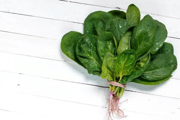 A bouquet of fresh spinach on a wooden table