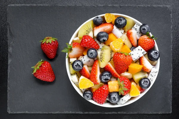 Kom Van Gezonde Salade Van Vers Fruit Een Donkere Tafel — Stockfoto