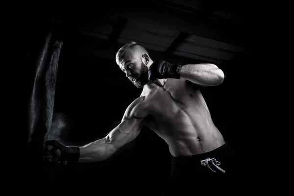 Férfi sportoló boxer lyukasztó a lyukasztó zsák a drámai éles li — Stock Fotó