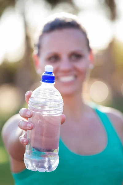 Athletin hält ihre Wasserflasche hoch — Stockfoto