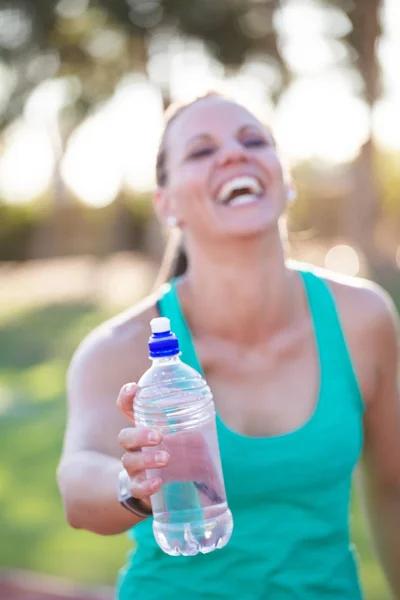 Athletin hält ihre Wasserflasche hoch — Stockfoto